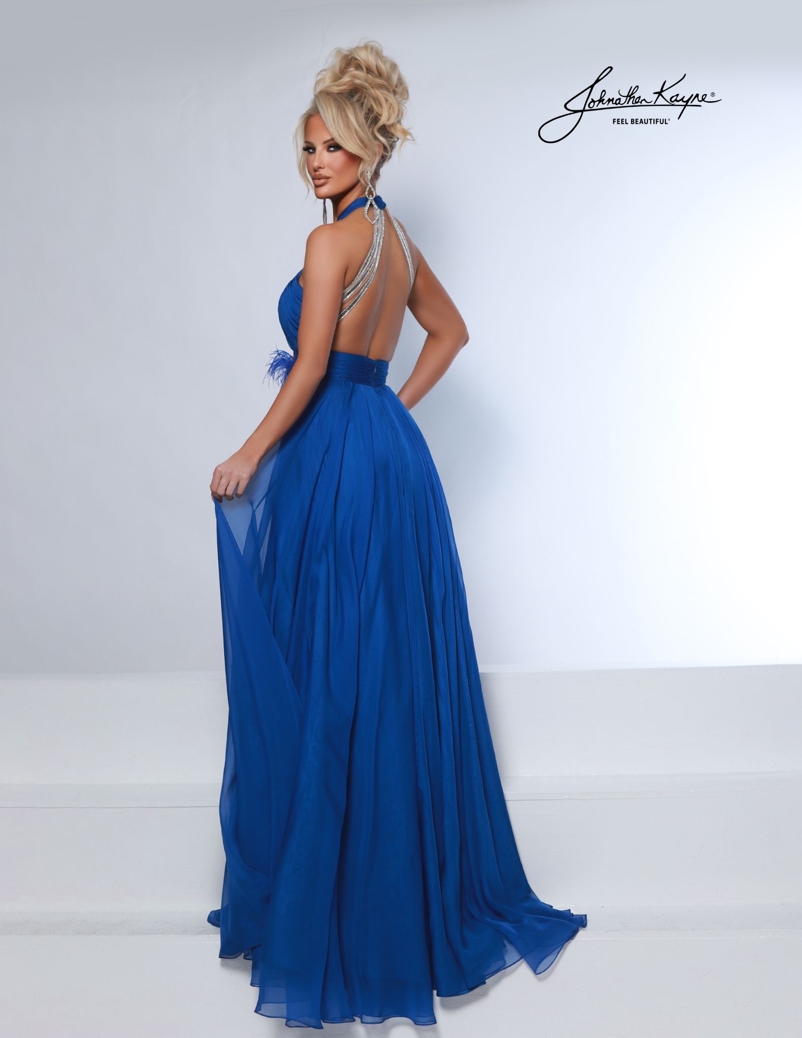 Back view of royal blue pageant dress with jeweled halter straps. Glamourous open-back chiffon gown with draped rhinestone detailing, ideal for national pageants, prom, stagewear, red carpets, and formal events.